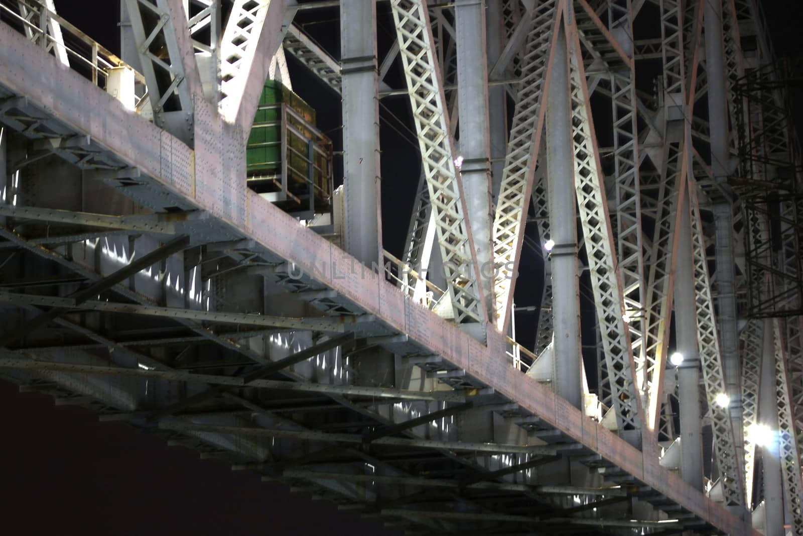 Supports of railway bridge, view from below, at night
