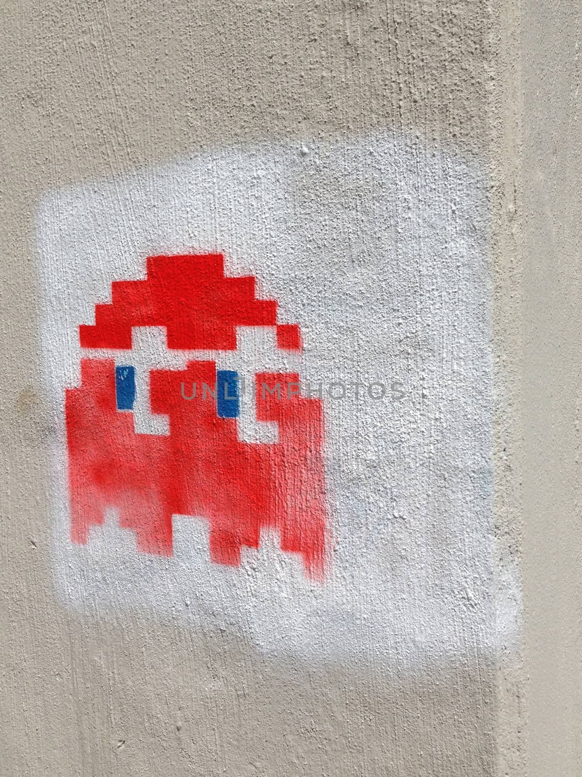 Image of a red Pac Man style graffiti or tag outside of a building.