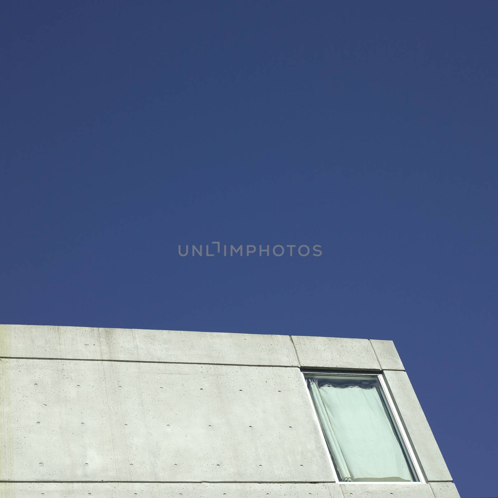 Corner of a modern concrete building against clear blue sky