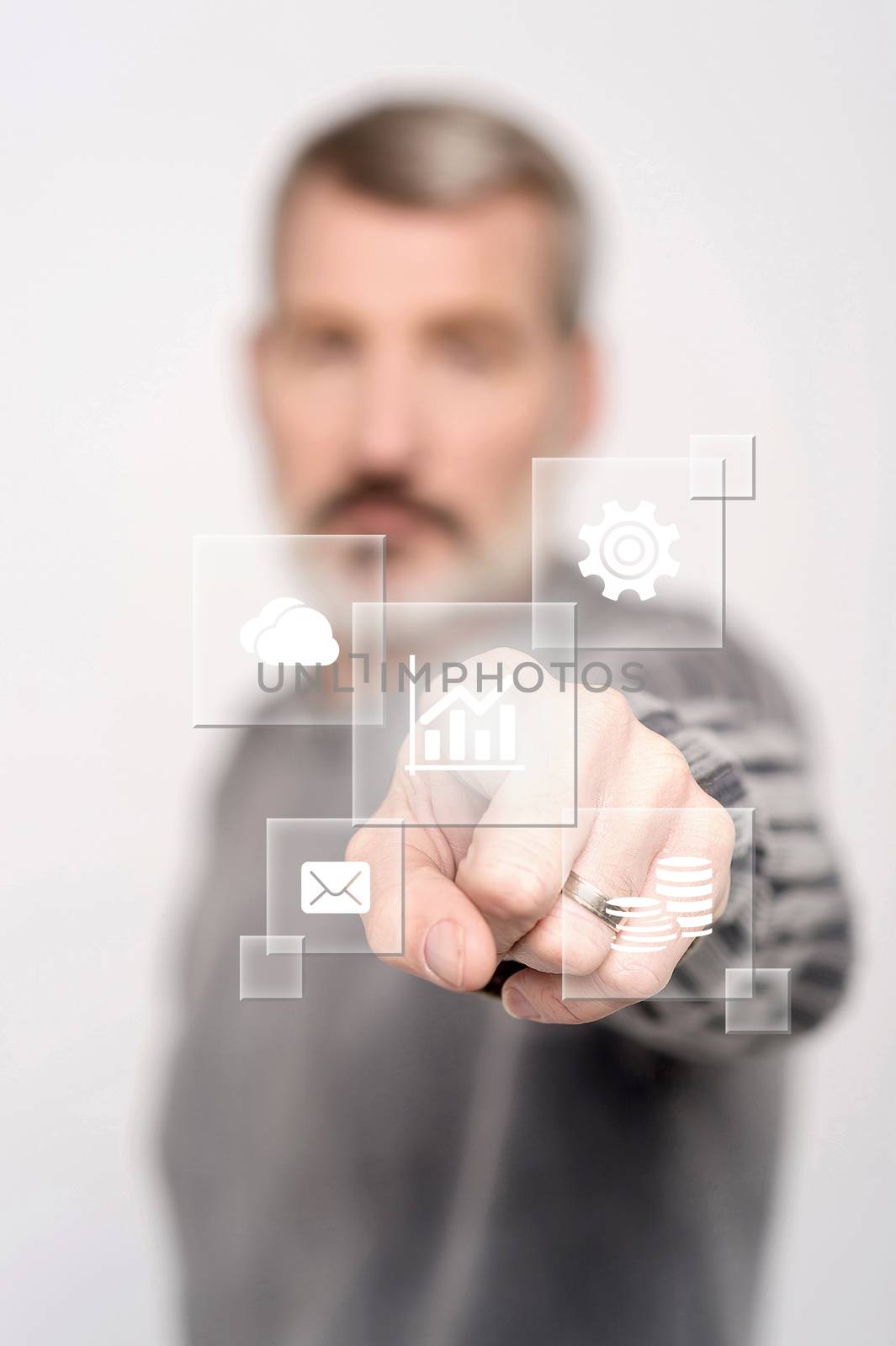 Man pointing icons on virtual screen by stockyimages