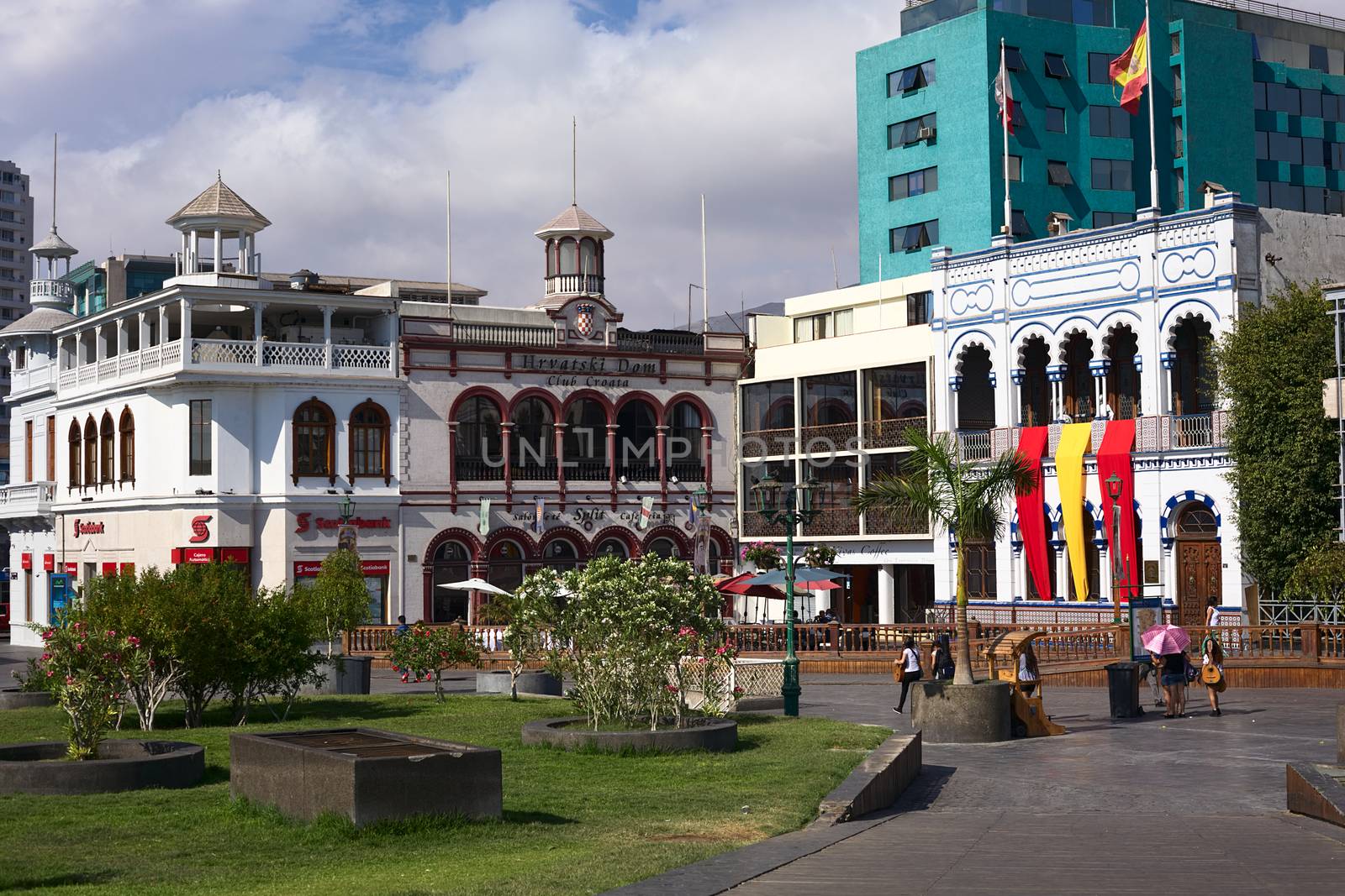 IQUIQUE, CHILE - JANUARY 22, 2015: Unidentified people on Plaza Prat main square with the buildings of Scotiabank, the Croatian Club and Casino Espanola on January 22, 2015 in Iquique, Chile. Iquique is a free port in Northern Chile.  