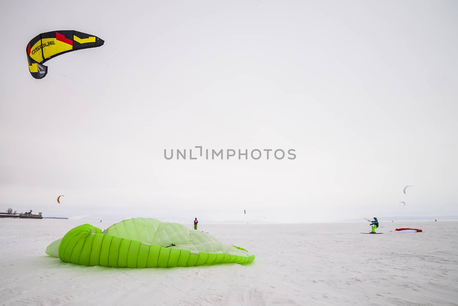 Kite surfer being pulled by his kite across the snow