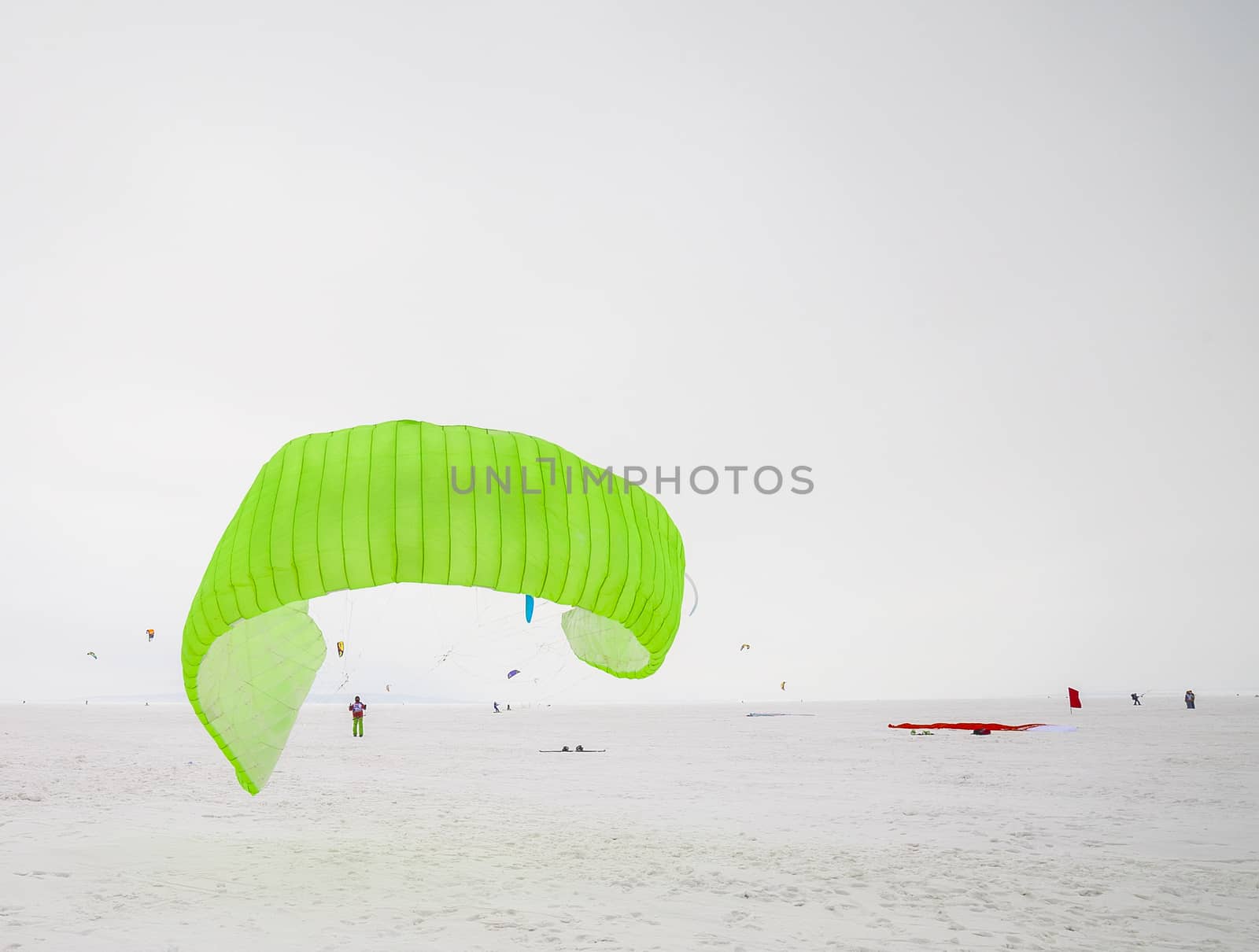 Kite surfer being pulled by his kite across the snow