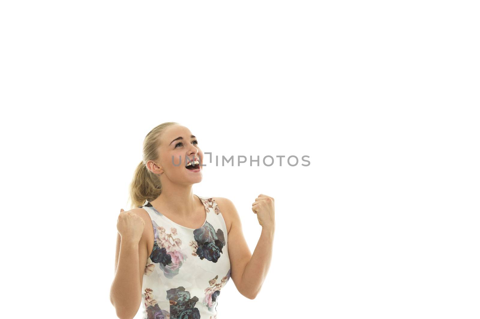 Elated jubilant young blond woman cheering and punching the air with her fists as she looks up with an excited grateful expression, isolated on white with copyspace