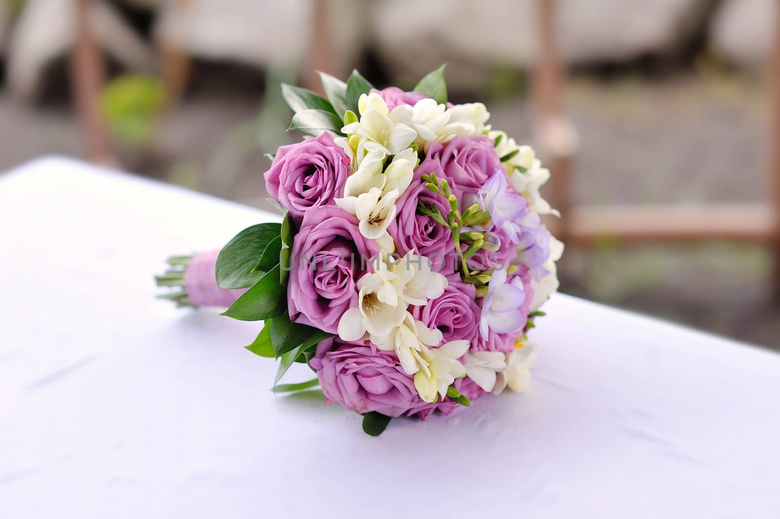 Bridal bouquet of purple roses on table