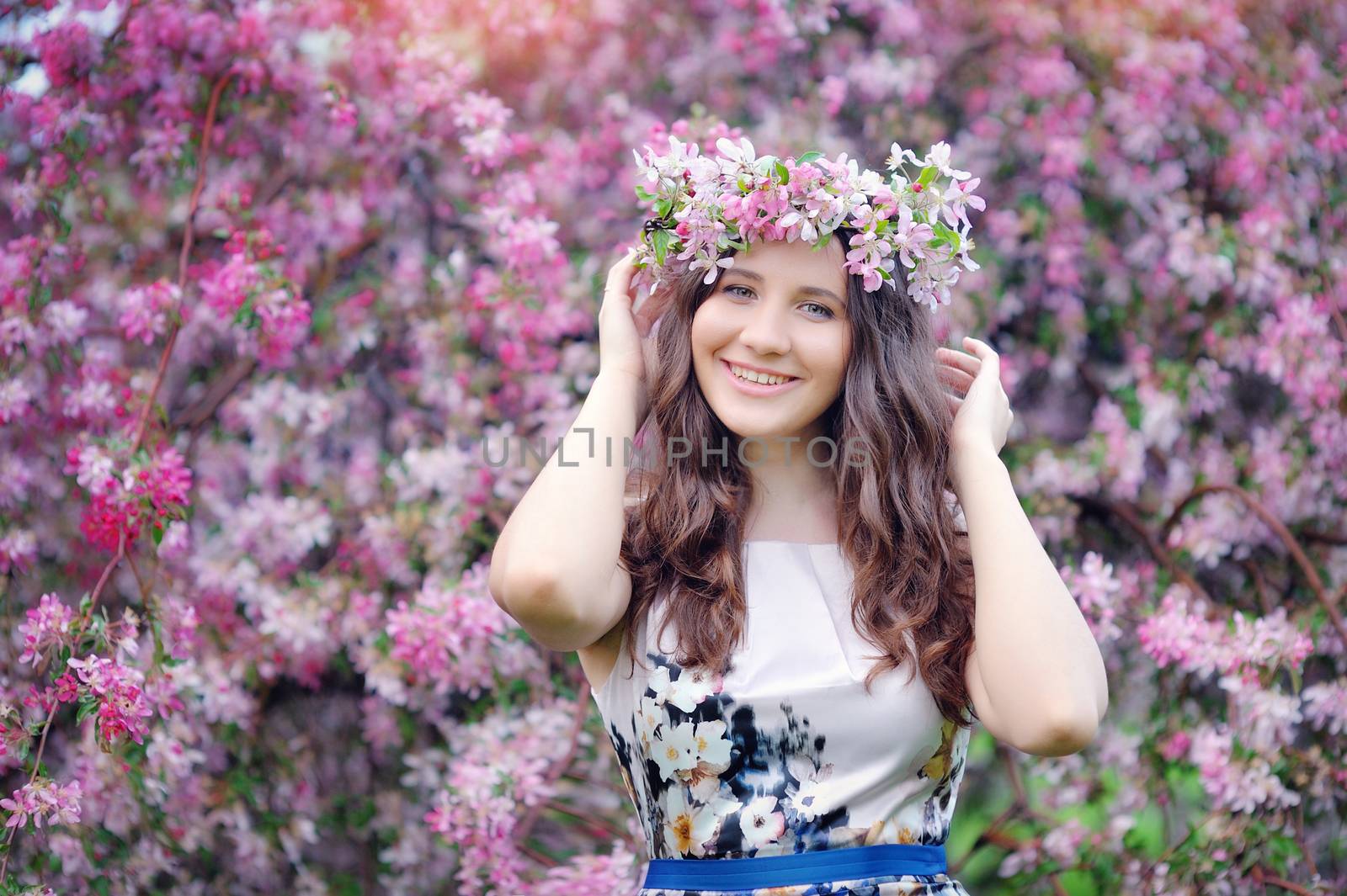 Beautiful woman walking in blossoming spring garden