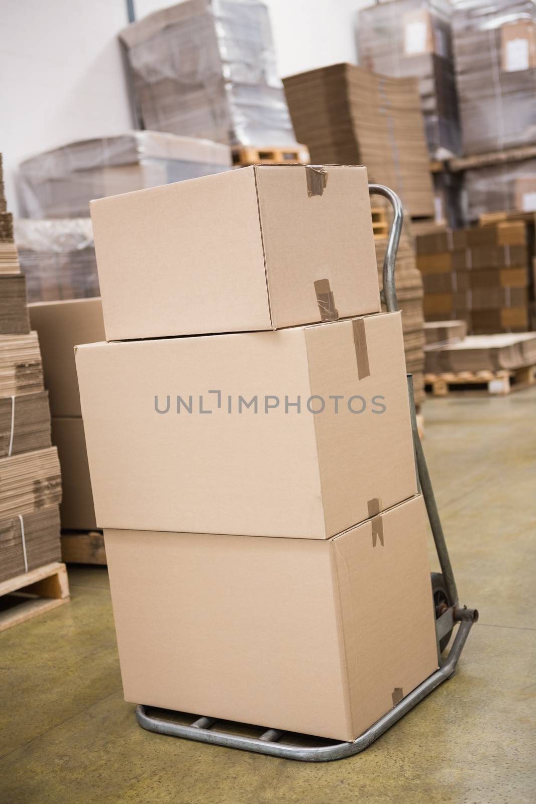 Boxes on trolley in warehouse by Wavebreakmedia
