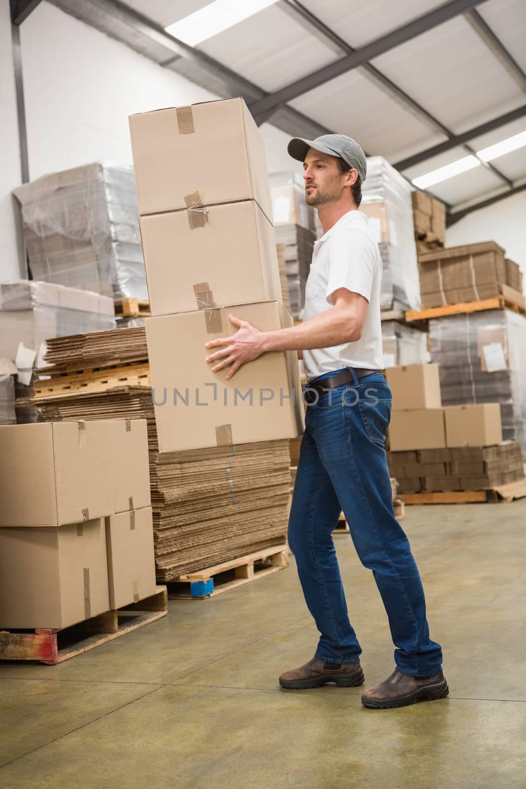 Side view of worker carrying boxes in warehouse