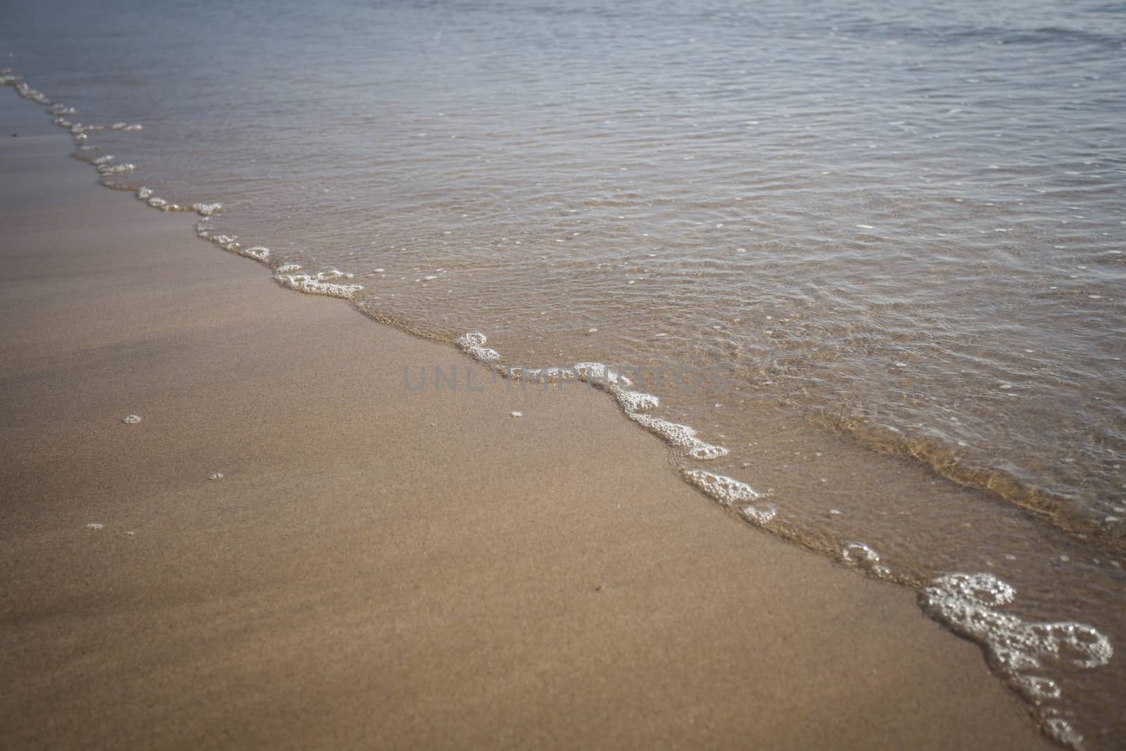 Close up of the tide line on a beach, sand and sea