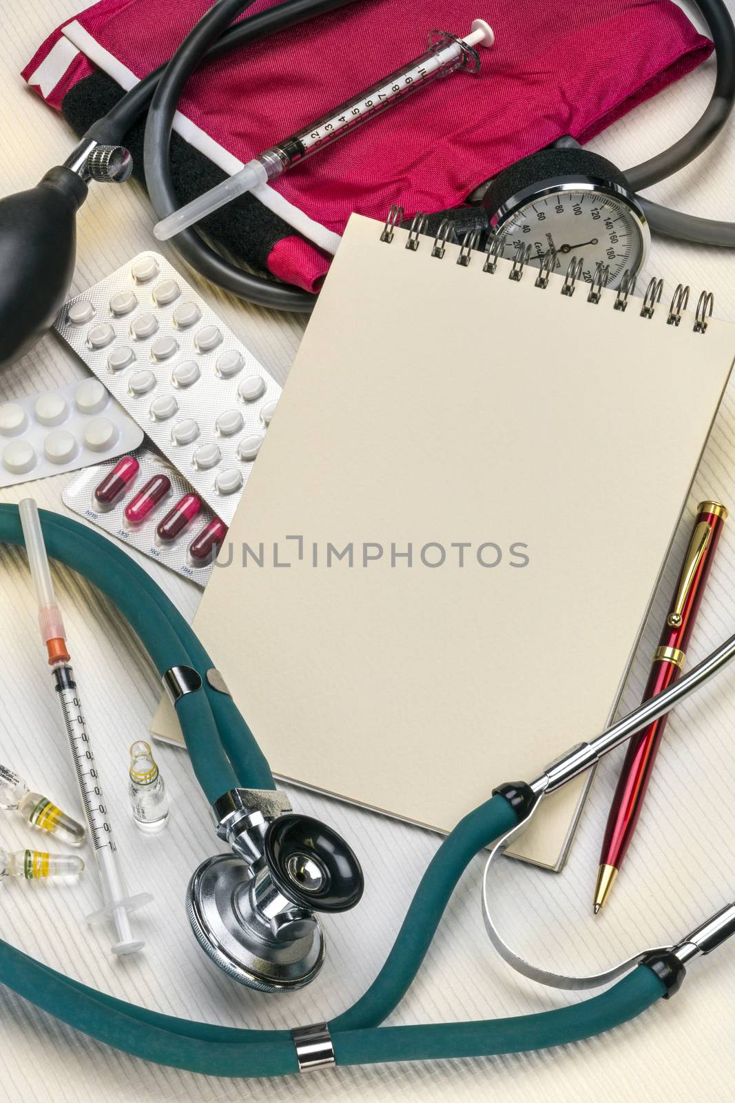 A doctors stethoscope and sphygmometer with syringes, drugs and a notepad - with space for text.