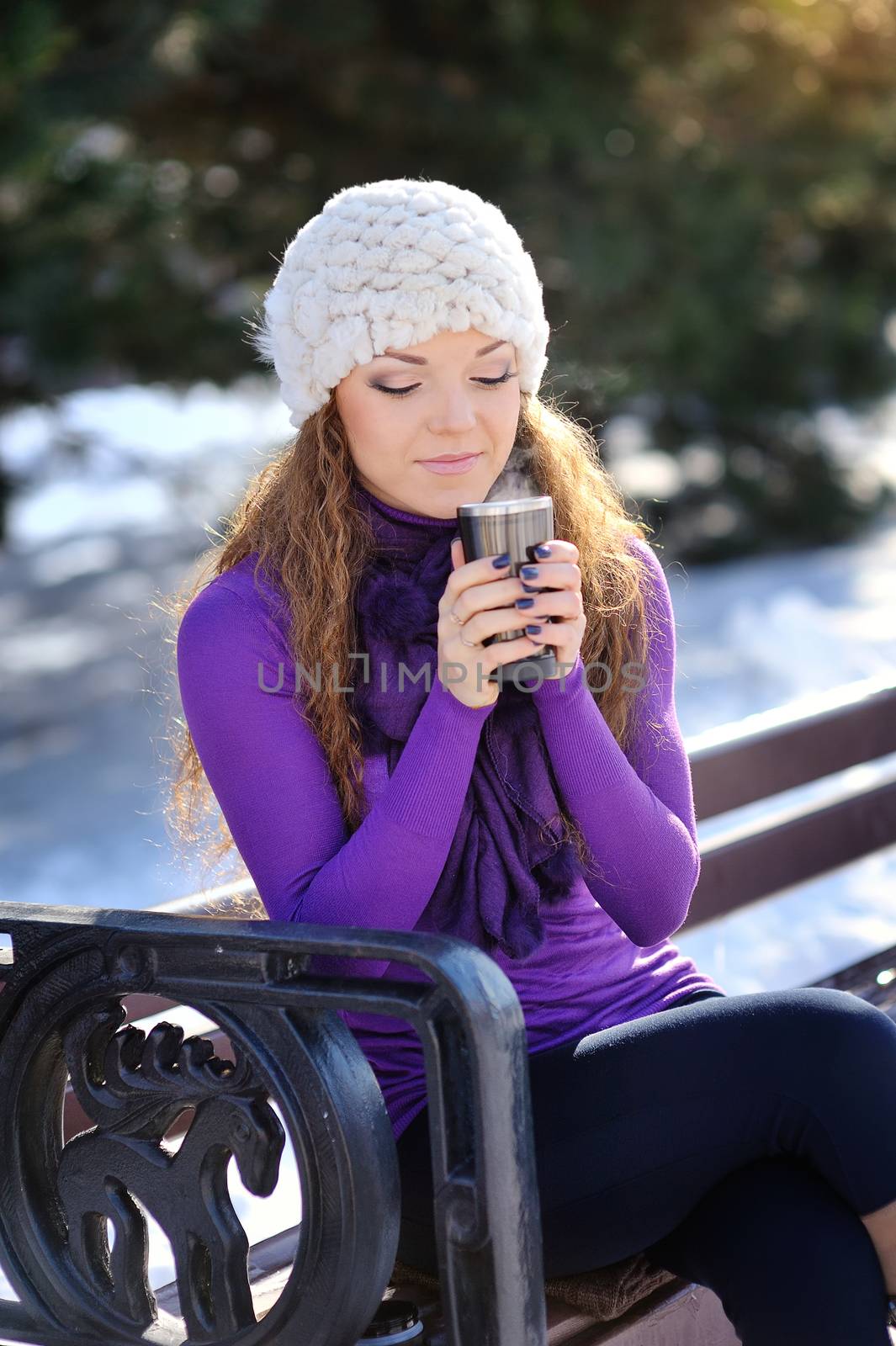 Winter woman with hot coffee on bench