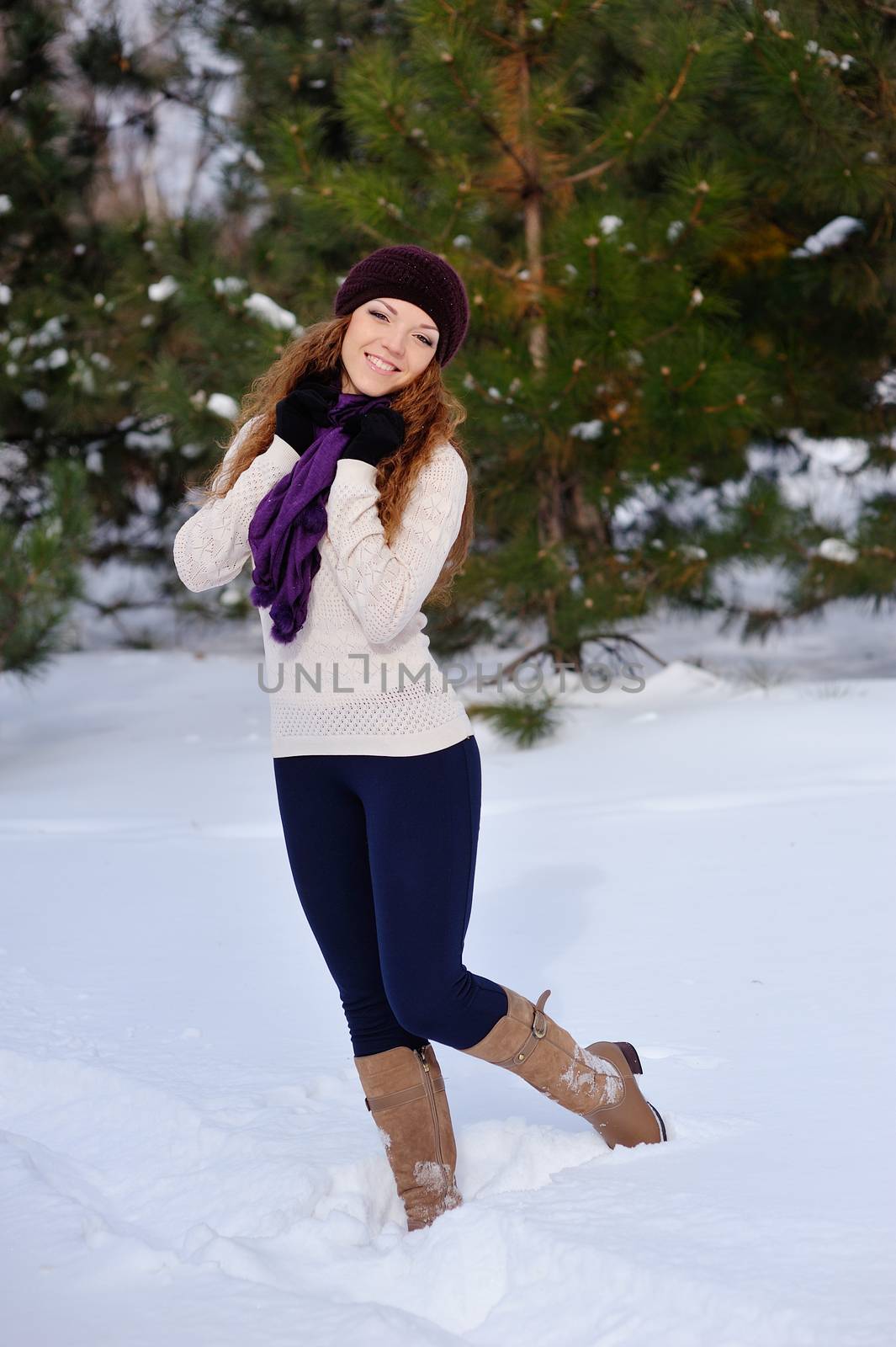 beautiful girl standing on background winter trees.