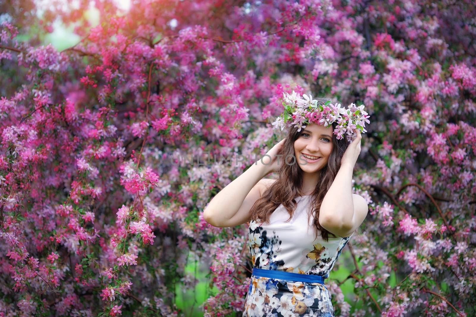 Beautiful girl outdoors spring portrait, young woman with flowers in green park, spring concept. cheerful teenager walking outdoor. series in portfolio