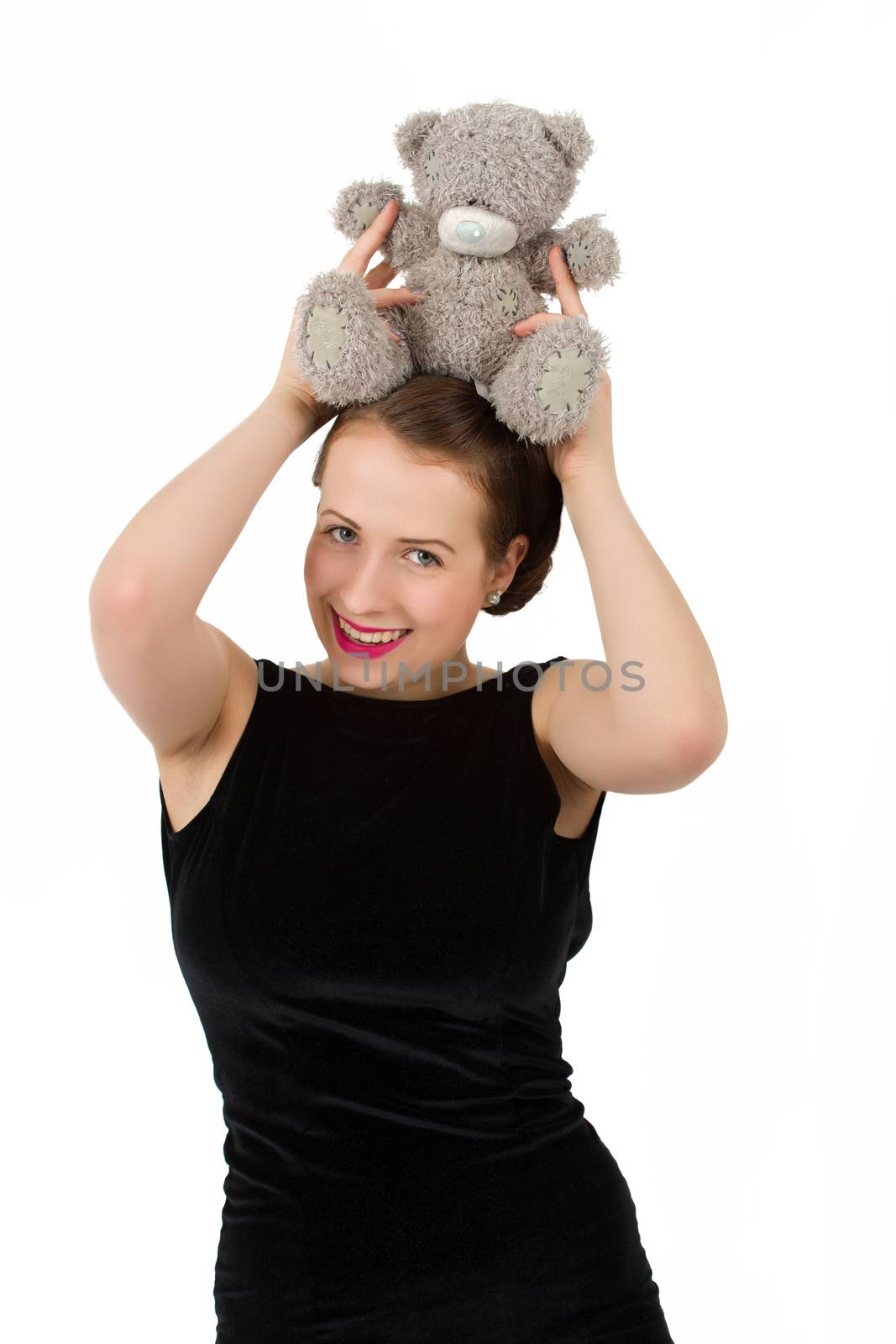 attractive smiling brunette holding teddy bear in a black dress and smiling
