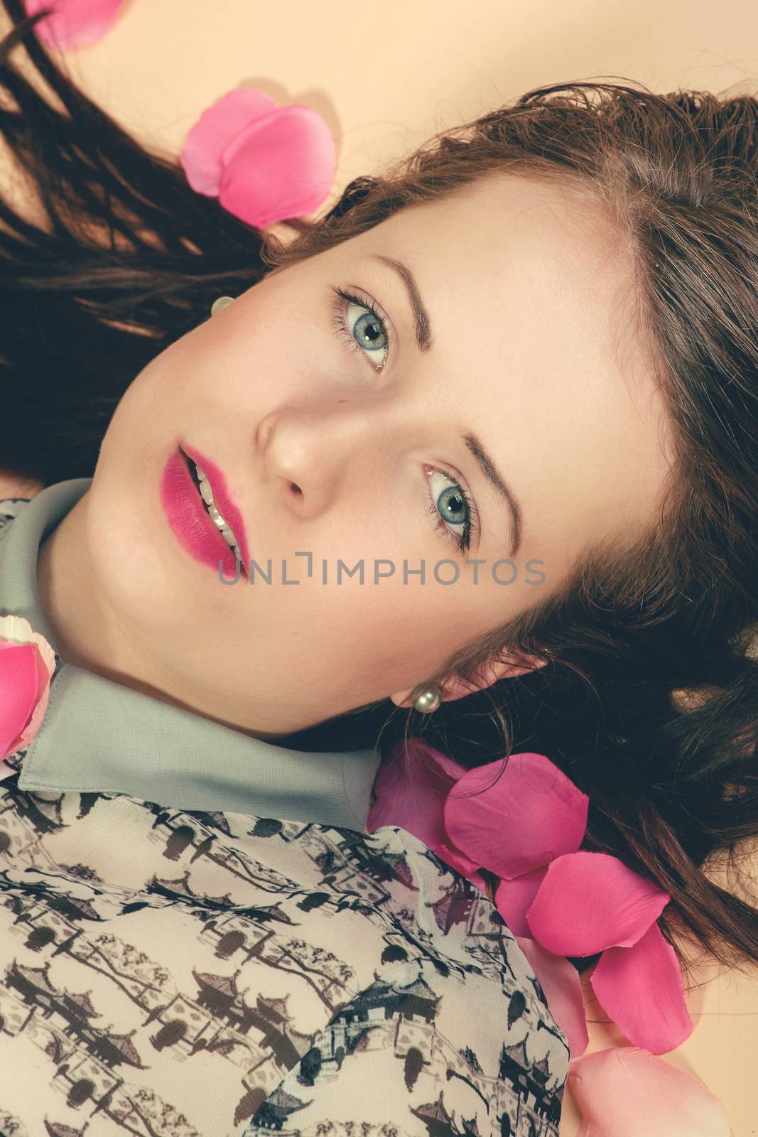 atractive brunette girl lying on beige background by artush