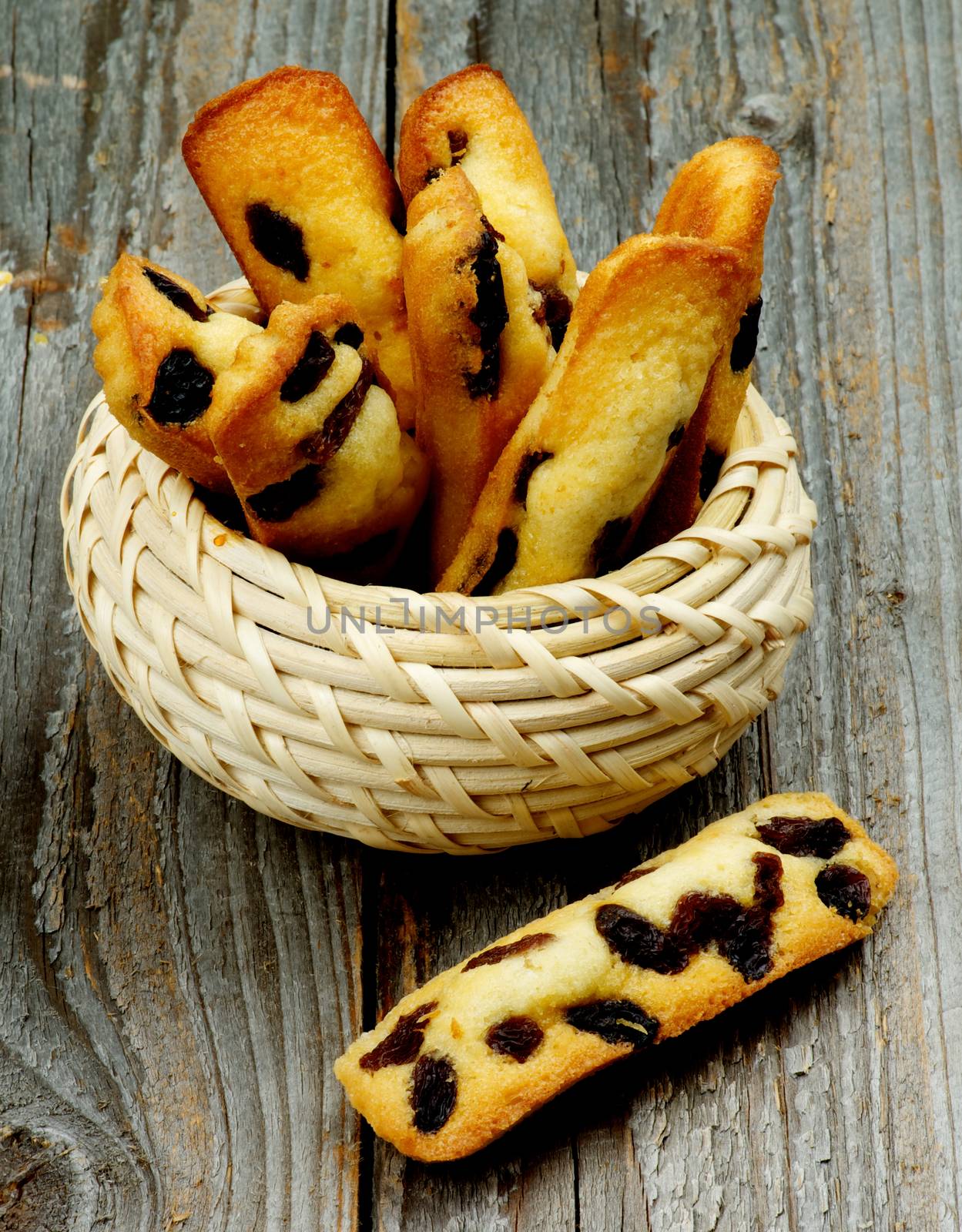 Tasty Biscuit Raisin Cookies in Wicker Bowl closeup on Rustic Wooden background