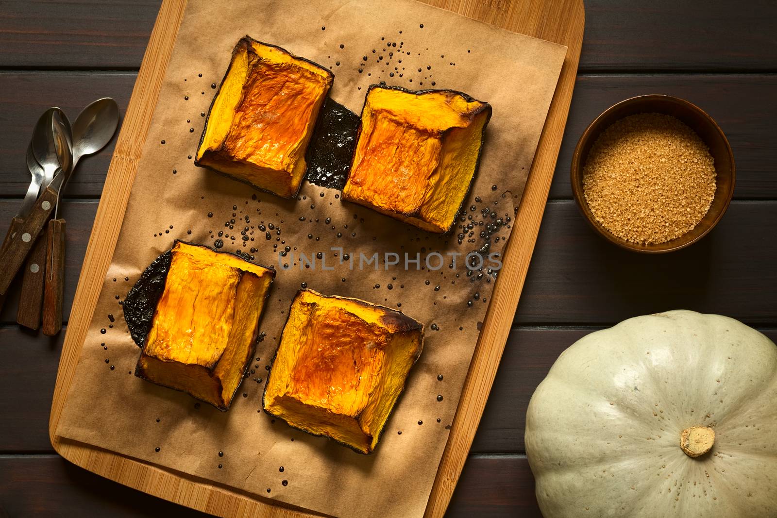 Baked pumkin pieces with caramelized sugar on top, a traditional autumn snack in Hungary, photographed overhead on dark wood with natural light