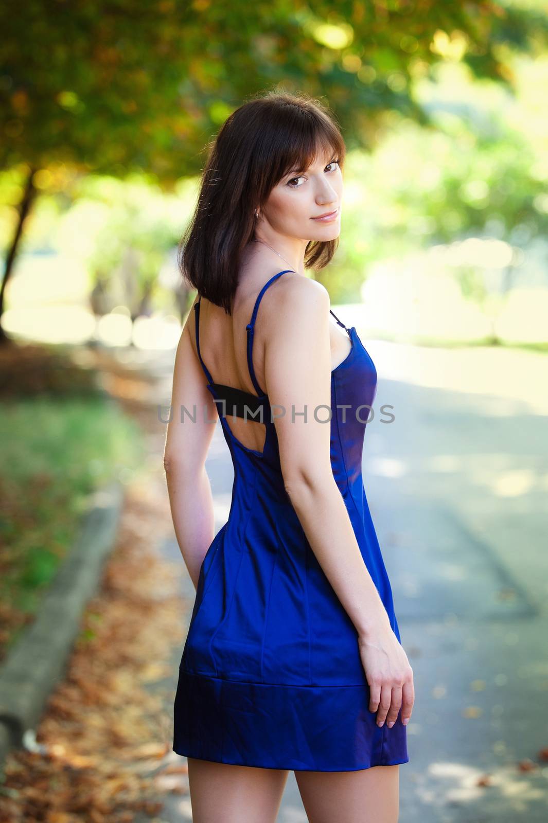Young beautiful girl in a blue dress walk in the summer park.