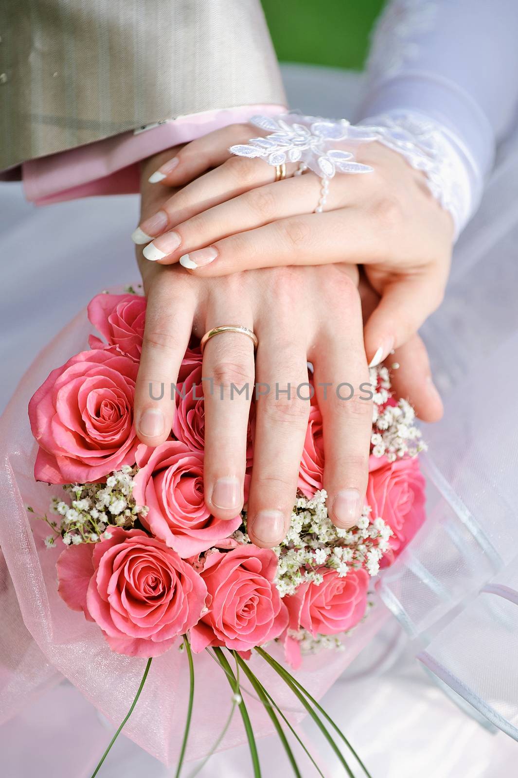 hand the bride and groom with the rings lying on the bridal bouquet.