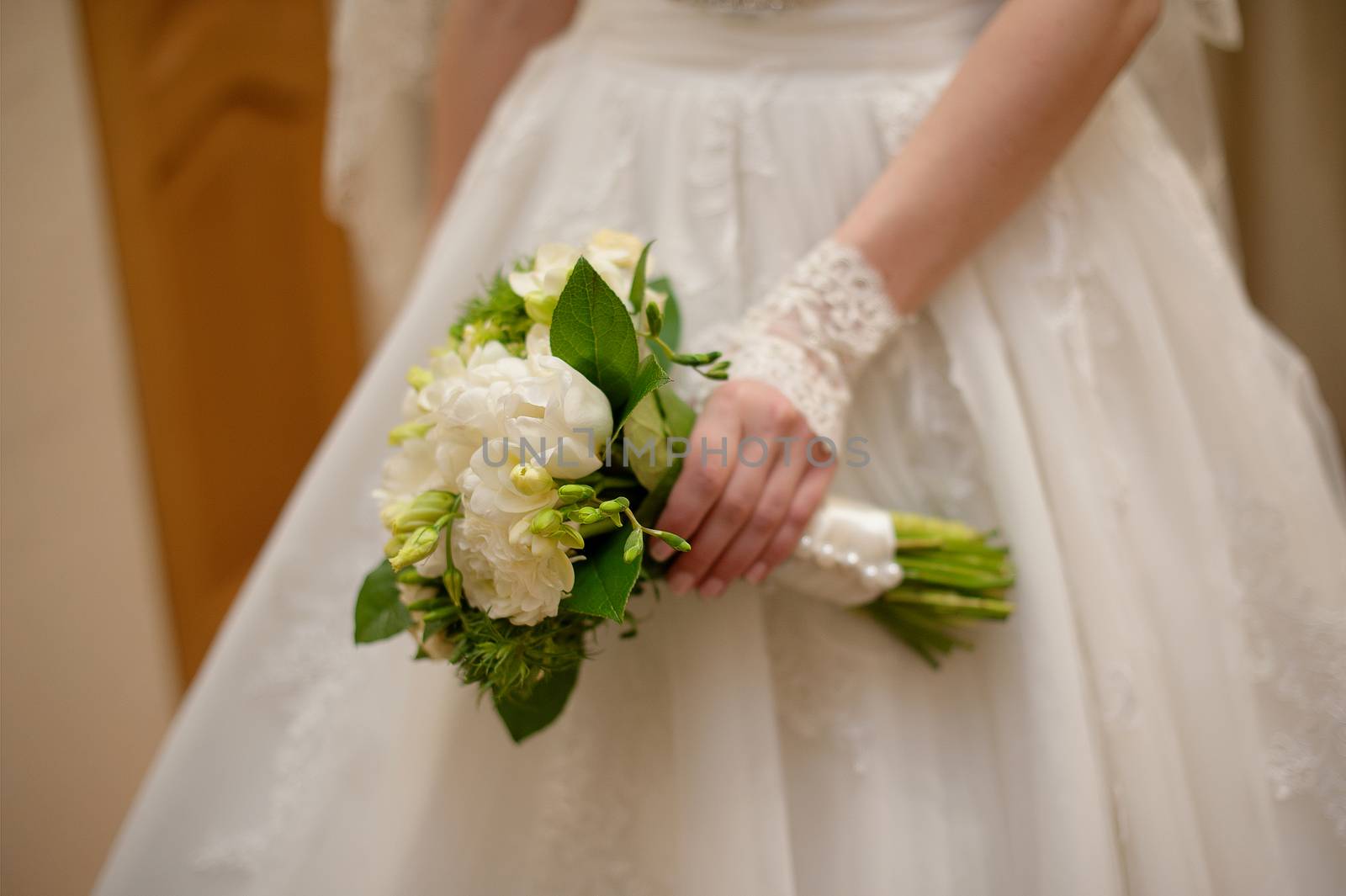 Bride holding white wedding bouquet of roses and love flower.