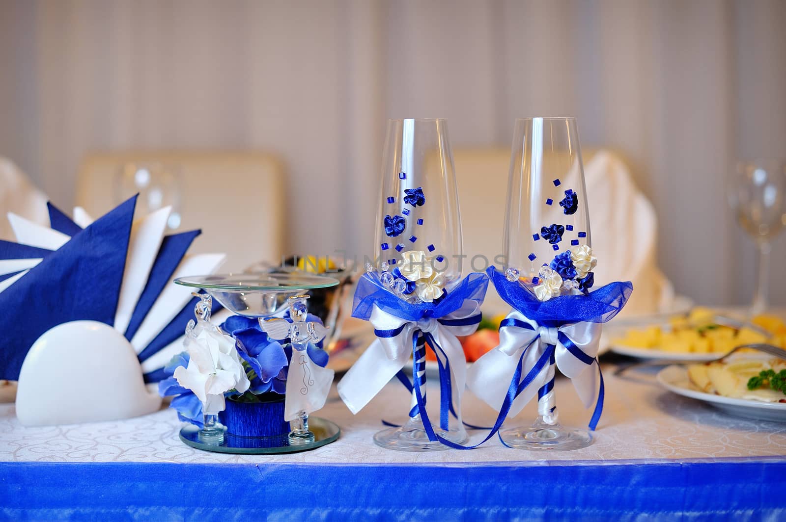 Two glasses and candle on served celebratory table.