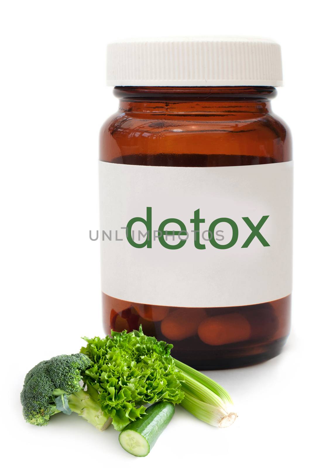 Medicine jar with detox pills and vegetables over a white background