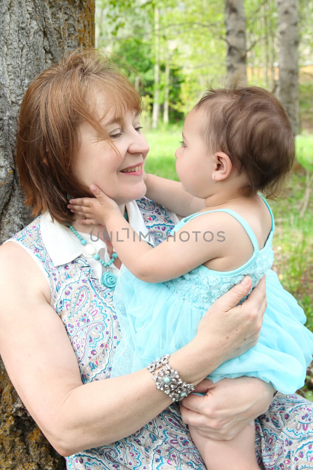 Grandmother and grandaughter sitting outside in the field