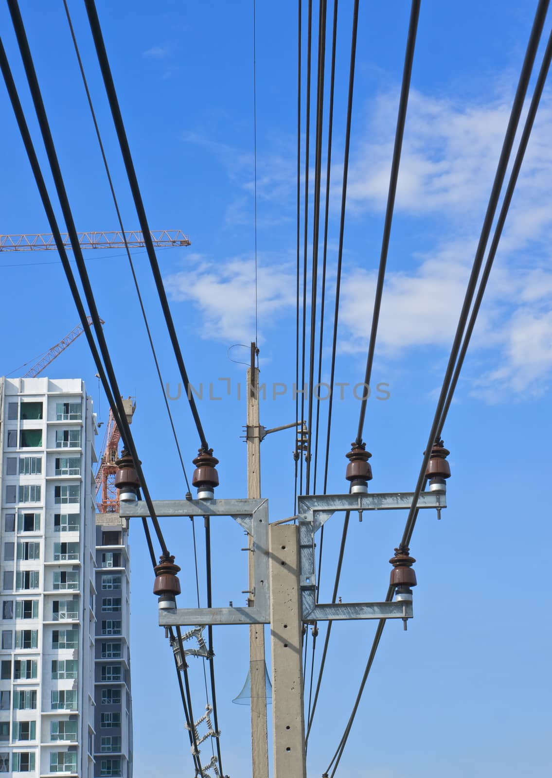 Electricity post and cable line with blue sky as background.