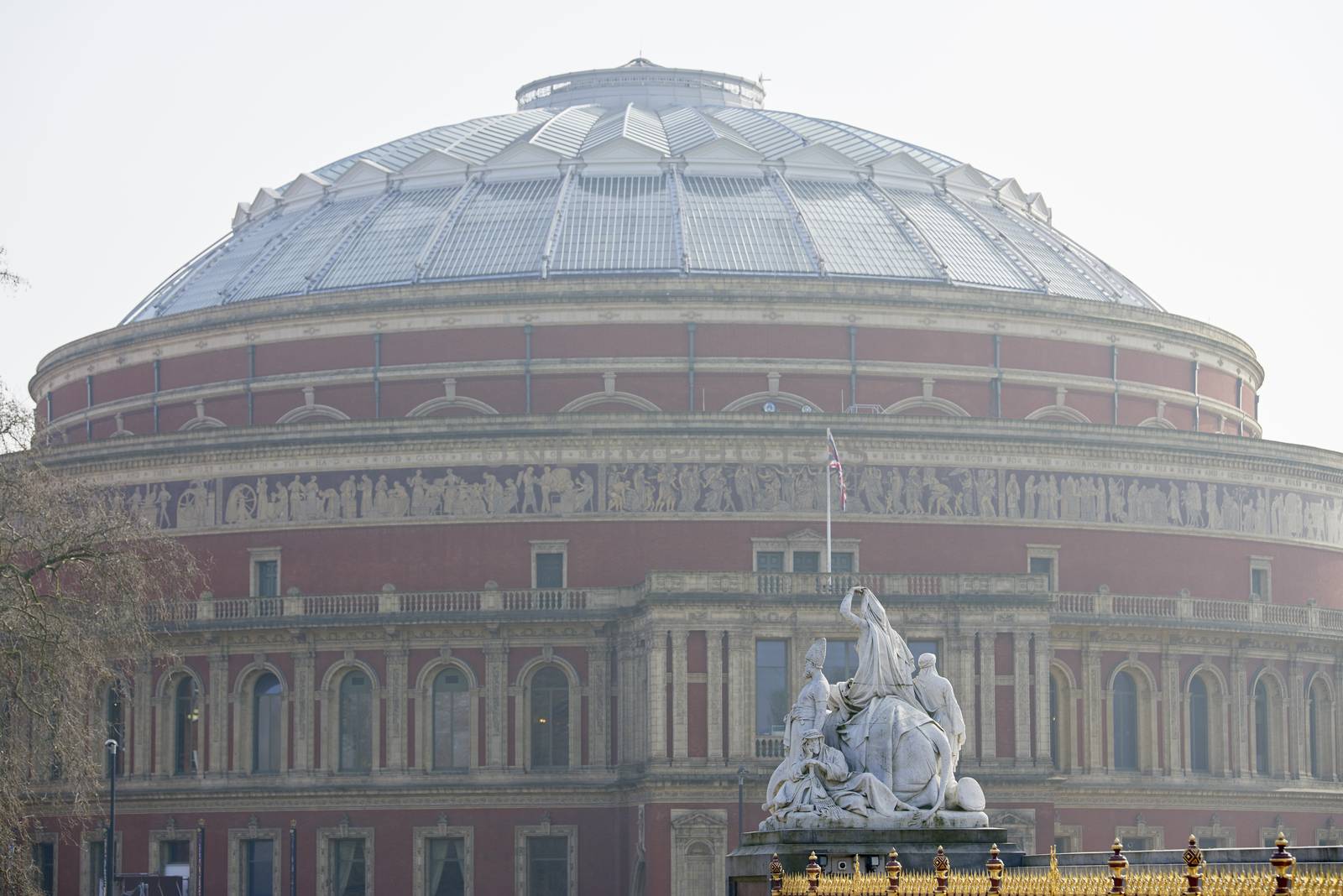 Albert Memorial statue overlooking hazy Royal Albert Hall, in London. The concert hall is home to the Proms, which take place each summer since 1941.