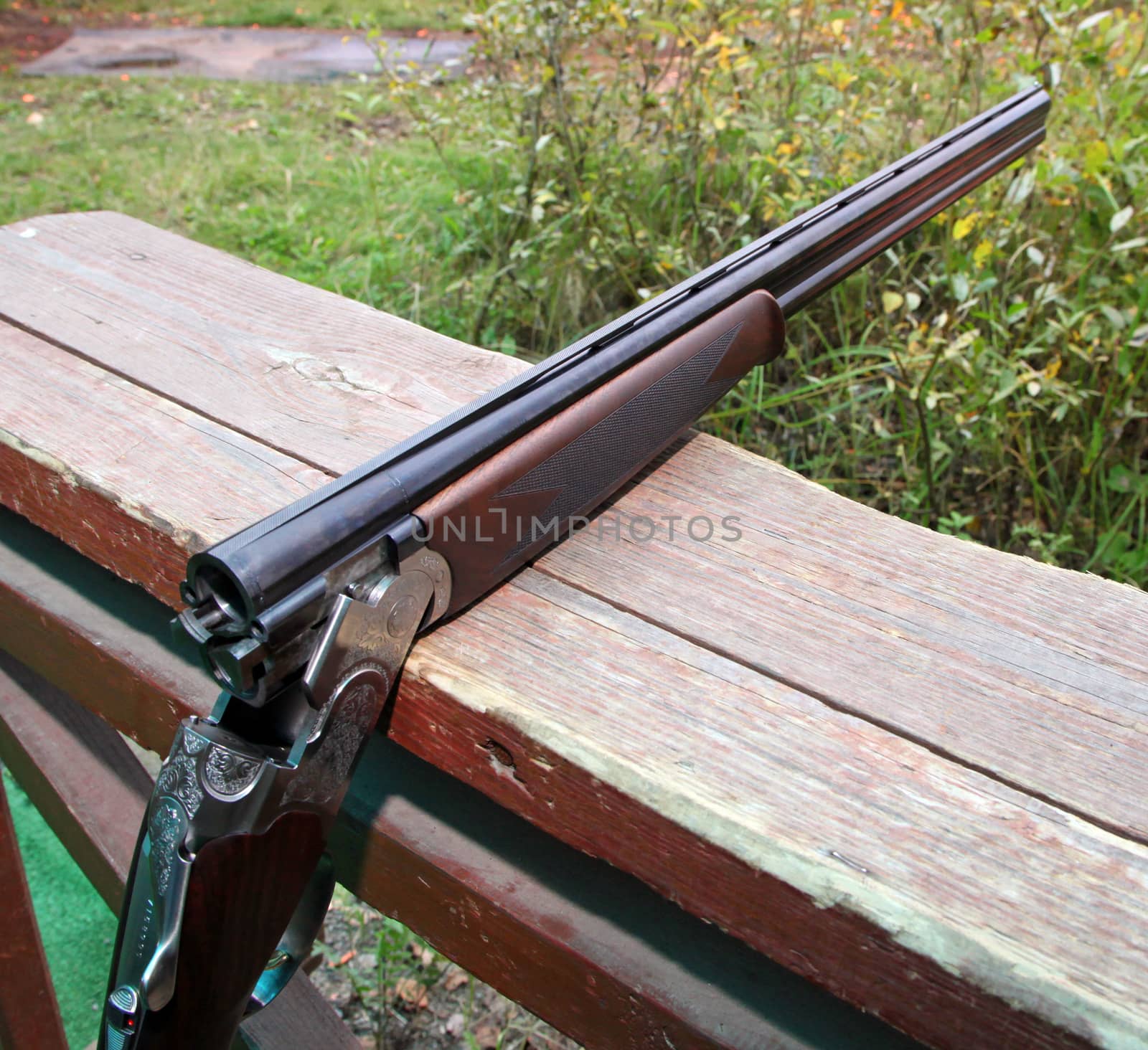 the shotgun lying on a wooden bench