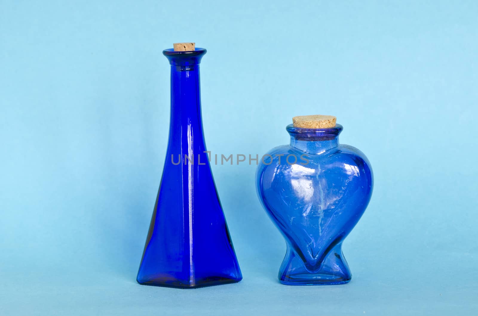 two beautiful blue decorative glass bottle on azure background