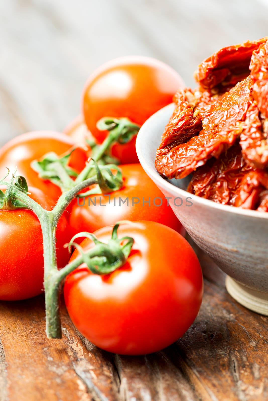 Set of tomatoes on wooden table vertical by Nanisimova