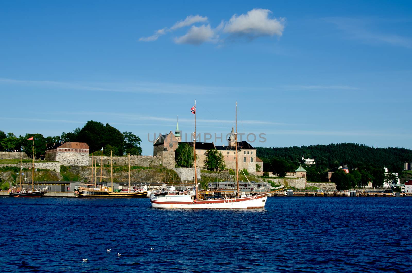 Old ship sailing in the Oslo fjord with Akershus fortress on background