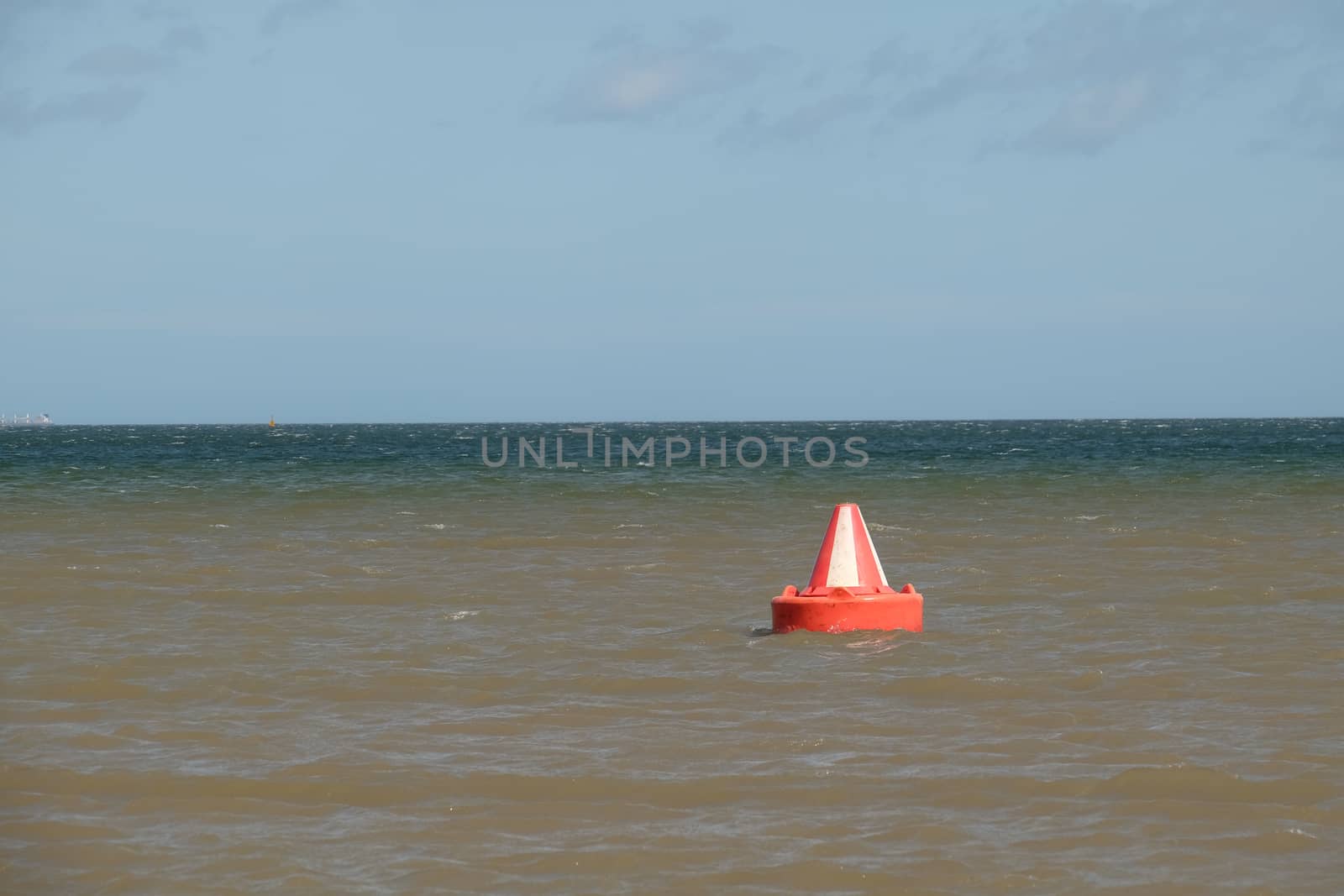 A red and white, Bedford buoy, safe water, inlet day marker on the sea.