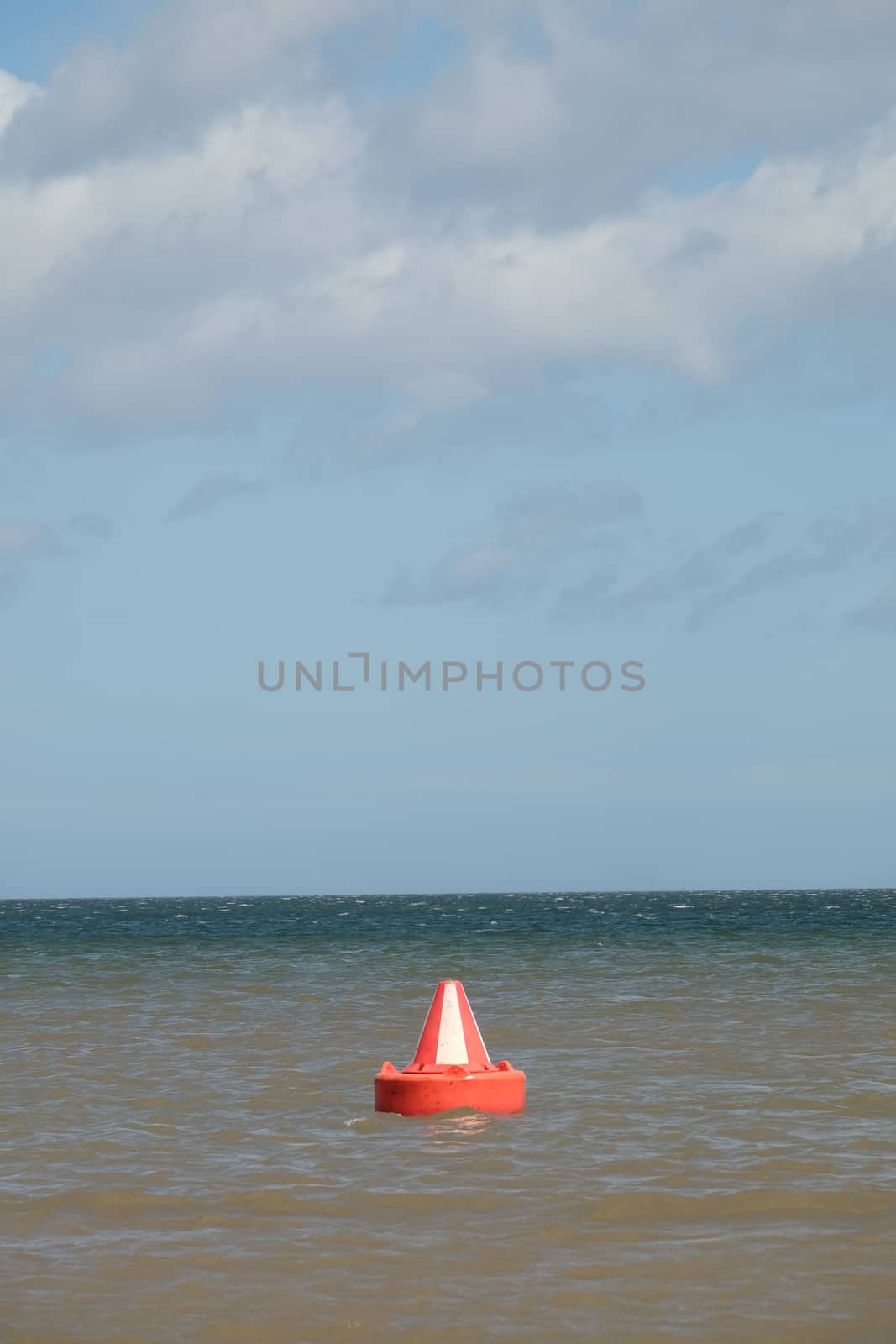 A red and white, Bedford buoy, safe water, inlet day marker on the sea.