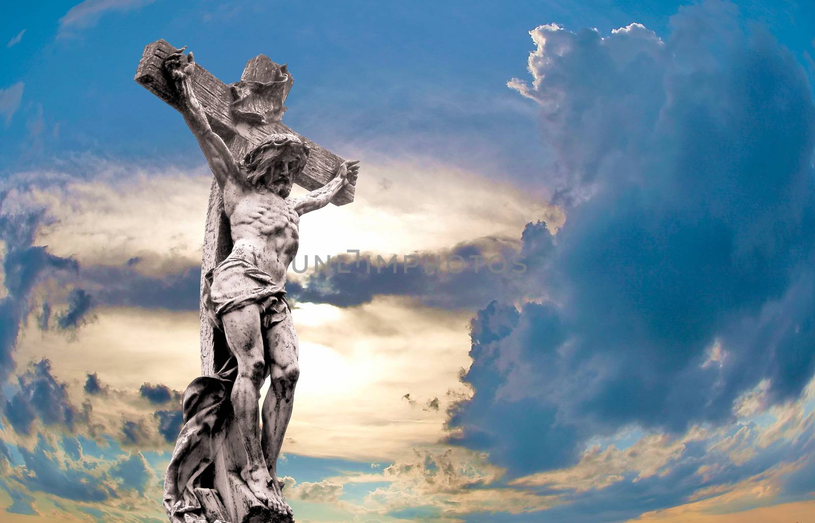 crucified Jesus Christ against dramatic sunset by fotosergio