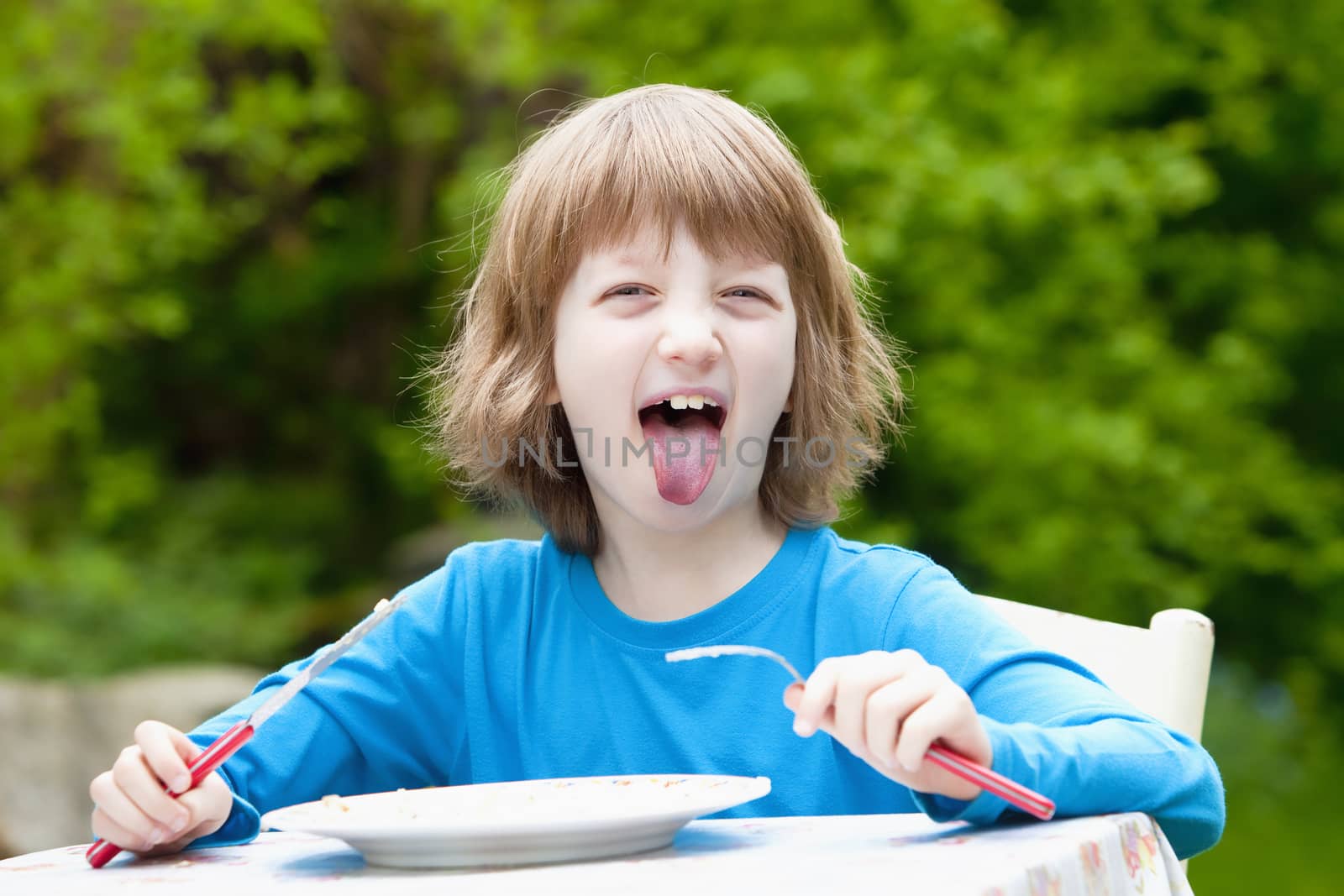 Blond Boy Eating Sticking out his Tongue