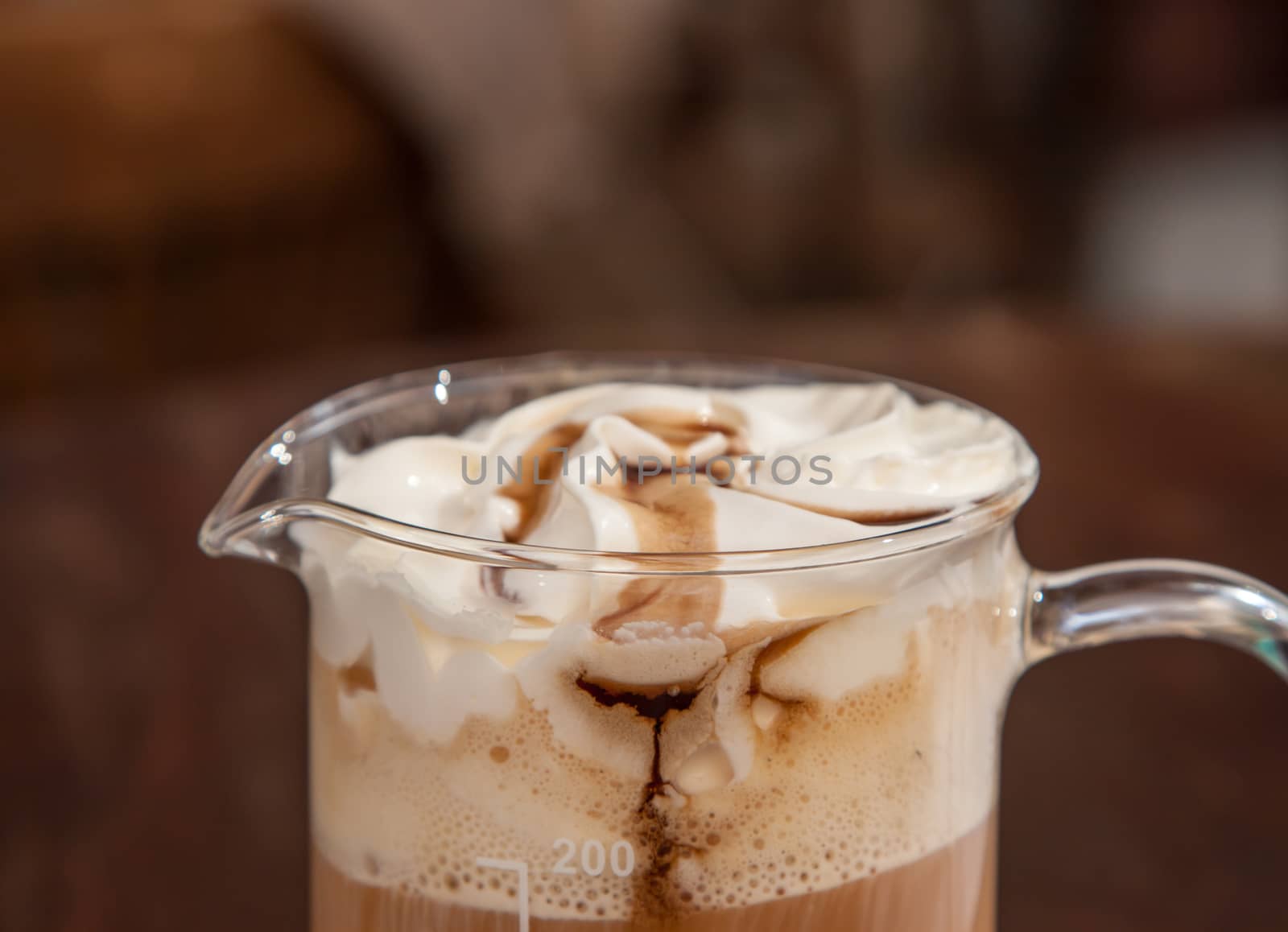 coffee in beaker with whipped cream and caramel topping