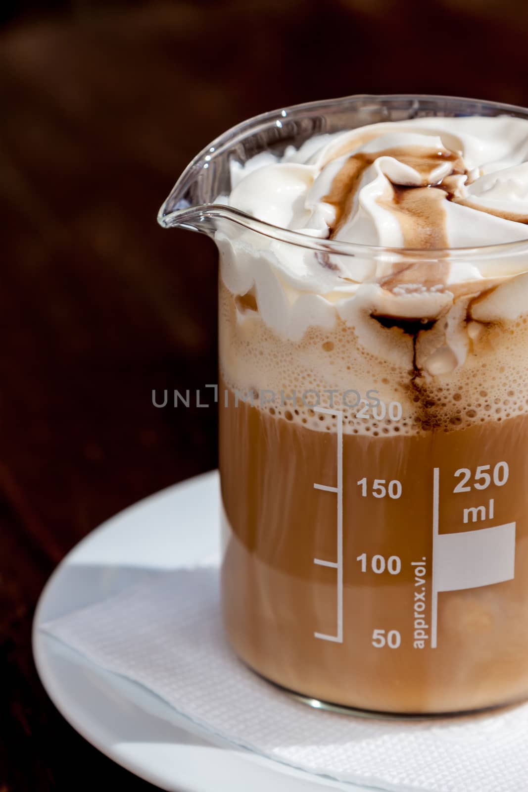 coffee in beaker with whipped cream and caramel topping