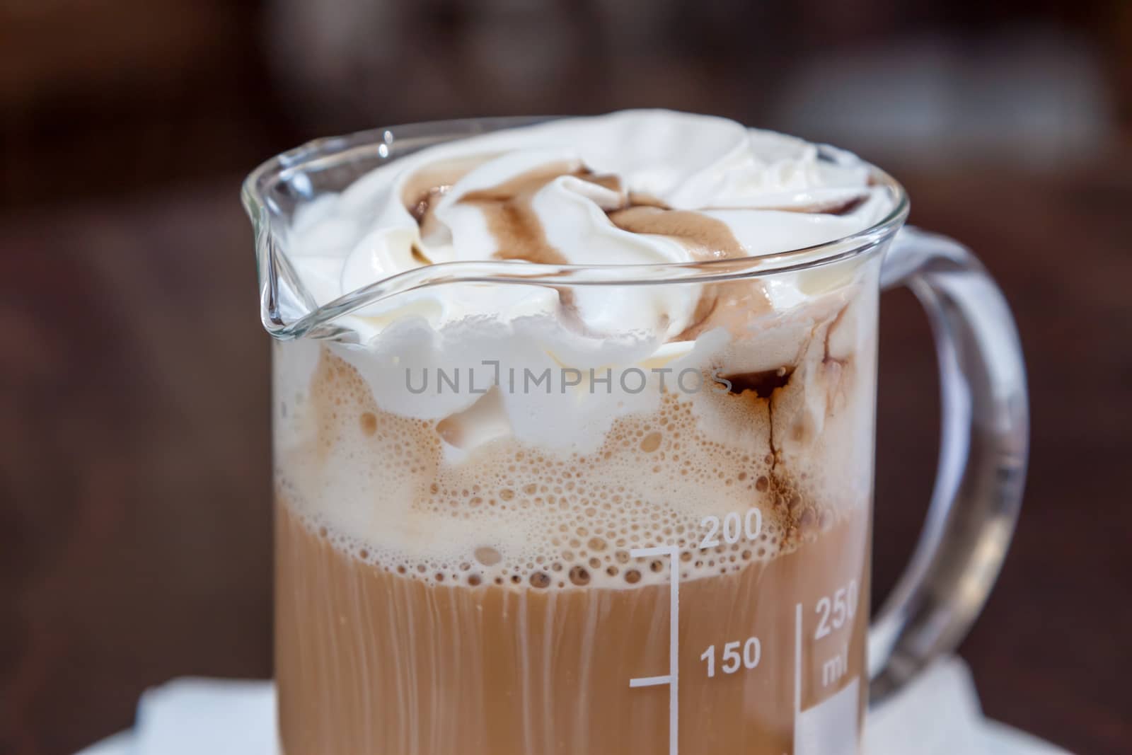 coffee in beaker with whipped cream and caramel topping