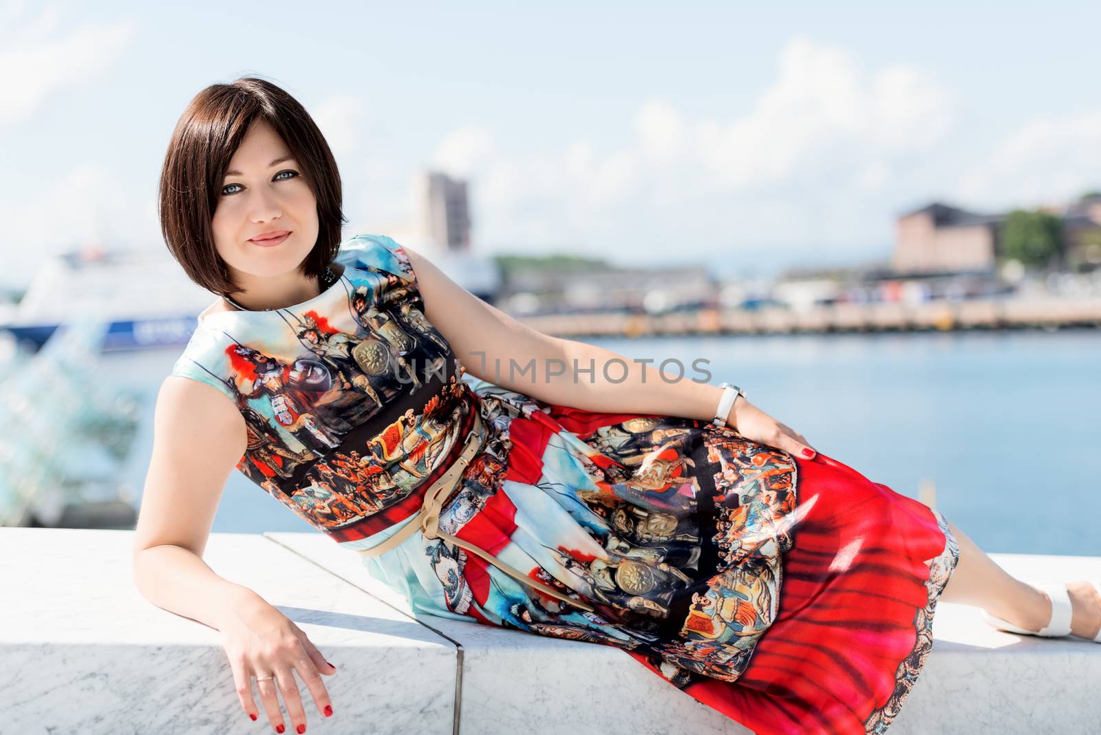 Brunette girl model in dress posing on exterior set