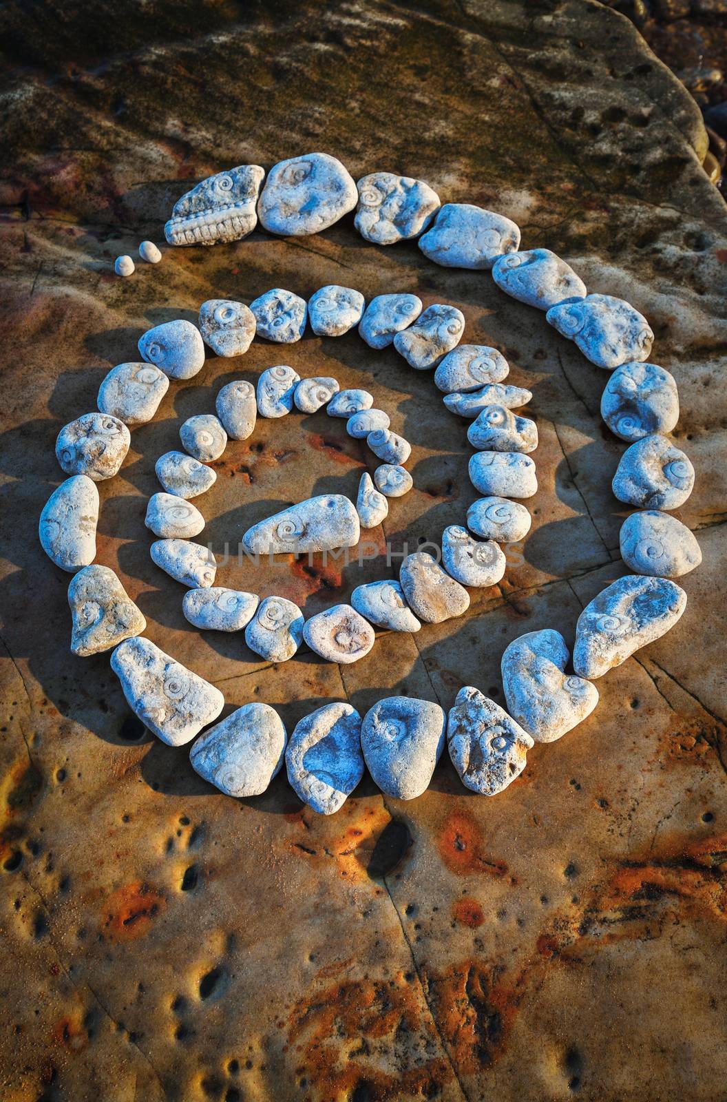 Spiral of pebbles on the sea boulder