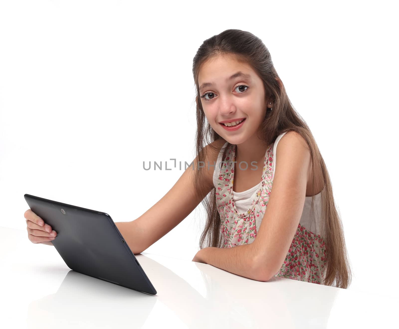 Beautiful pre-teen girl with a tablet computer. Isolated. Clipping path for the screen