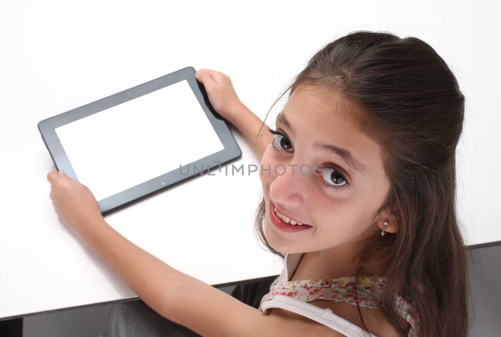 Beaitiful pre-teen girl using a tablet computer by Erdosain