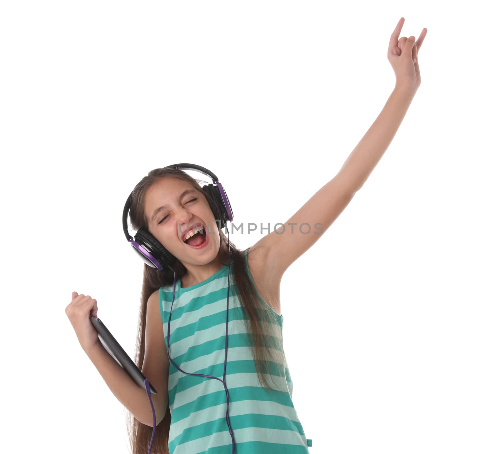 Beautiful pre-teen girl dancing and going crazy using a tablet computer and headphones