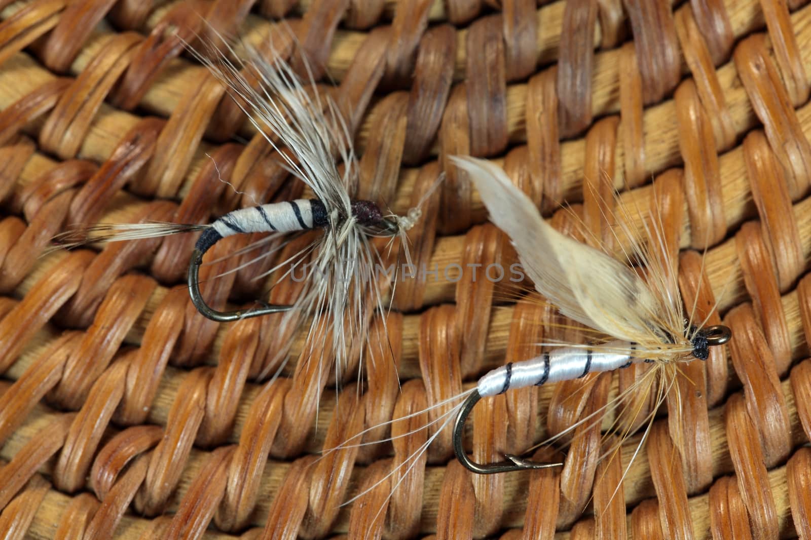 Macro photo of an artificial fly for fly fishing on a basketwork background.