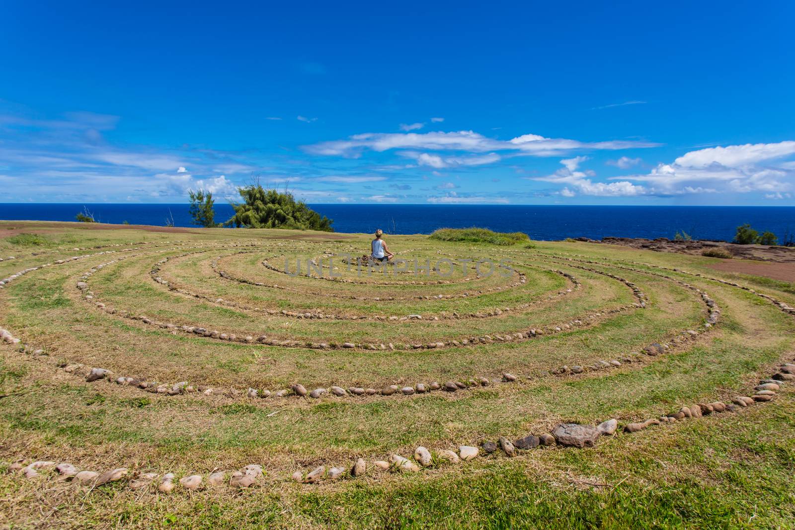 Person Sitting in Maui Labyrinth by Creatista