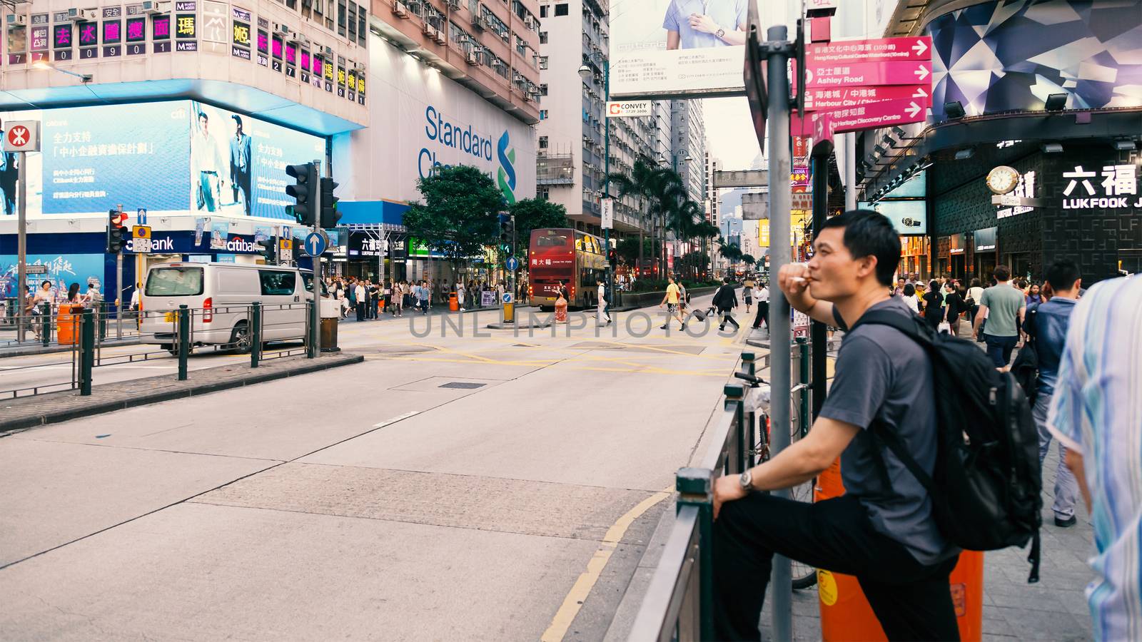 A man smoking and waiting for the bus, Tsim Sha Tsui, Hong Kong, China, 21 June, 2013.