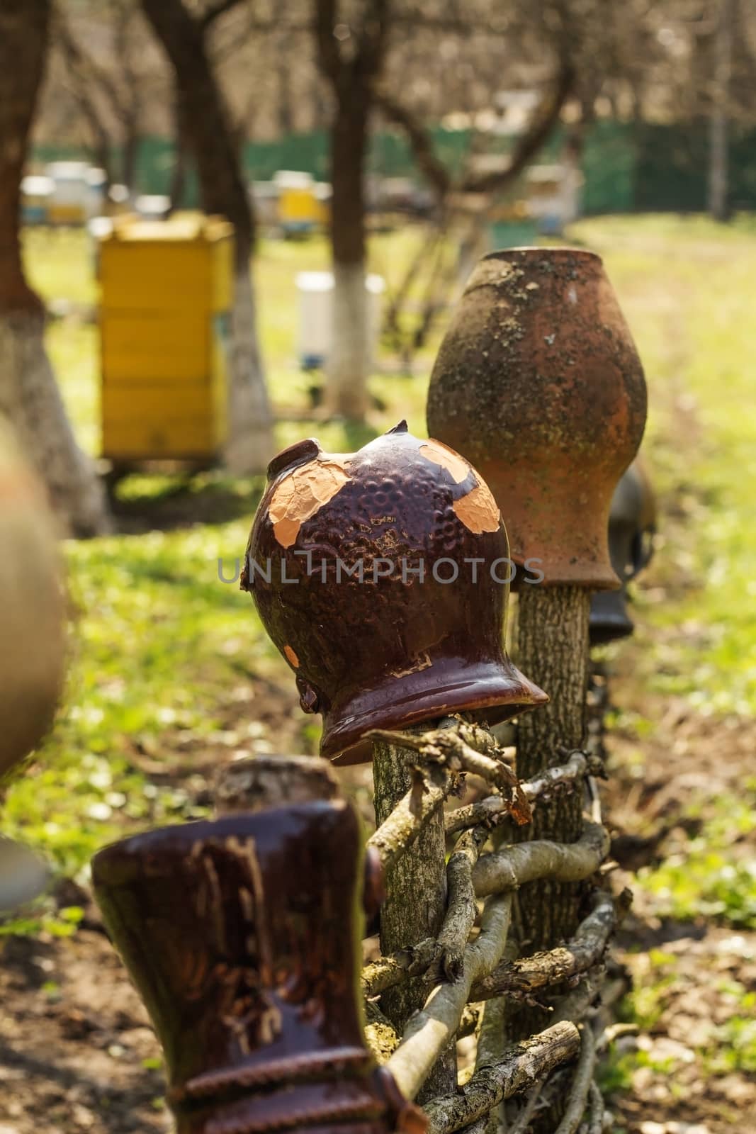 Old traditional clay jug hanging on the wooden fence. by serhii_lohvyniuk