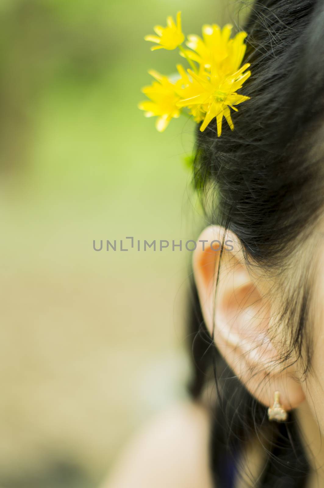 Woman with a flower behind her ear. For your commercial and editorial use